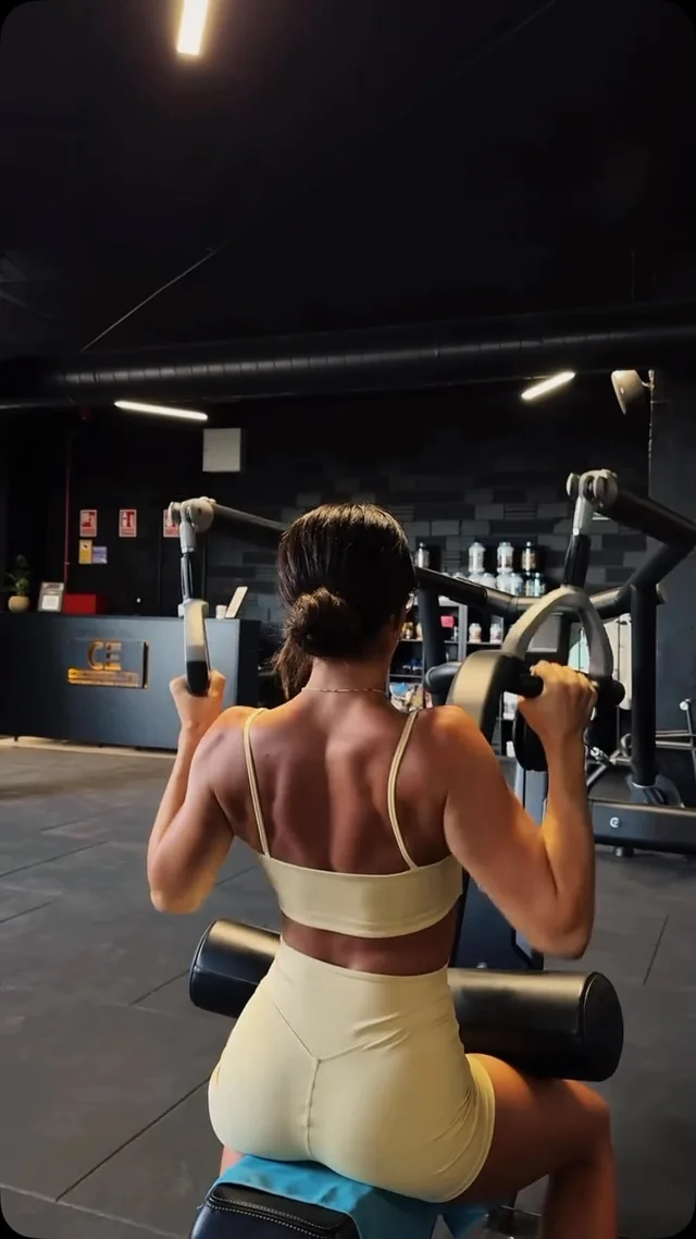 Una deportista realizando tracciones en una máquina de CrossElite, junto a la recepción del centro